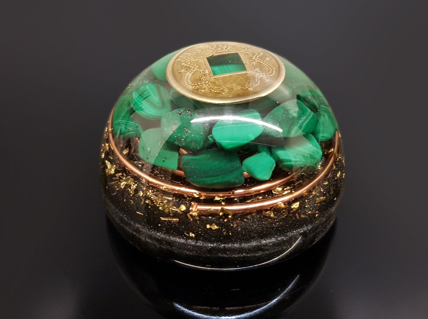 Hemisferio de cúpula de orgonita con malaquita y moneda de riqueza.