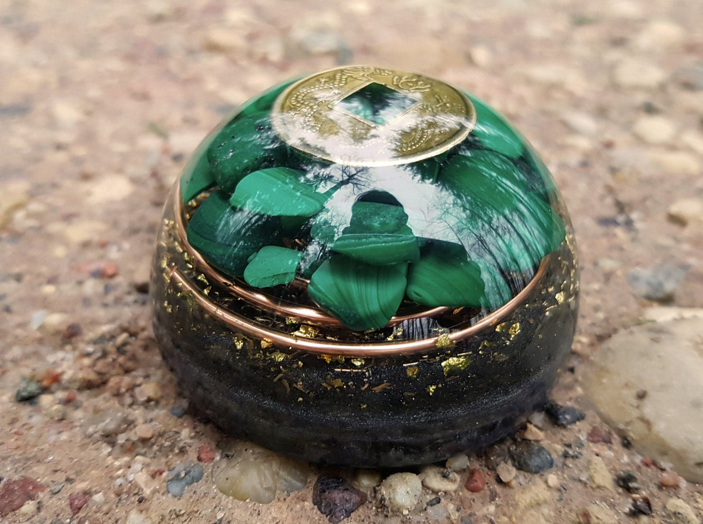 Hemisferio de cúpula de orgonita con malaquita y moneda de riqueza.