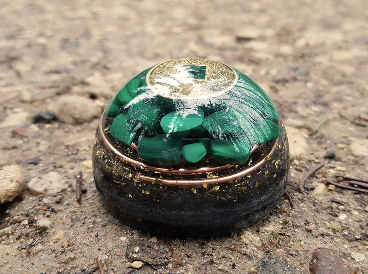 Hemisferio de cúpula de orgonita con malaquita y moneda de riqueza.